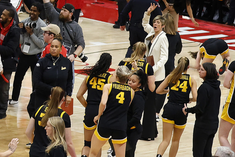 Clark, seen at top right, fell down on the court after a fan collided with her after storming the court on Sunday.