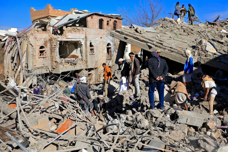 Residents inspect the damage following overnight air strikes by the Saudi-led coalition targeting the Houthi-held capital, Sanaa, on Jan. 18, 2022.