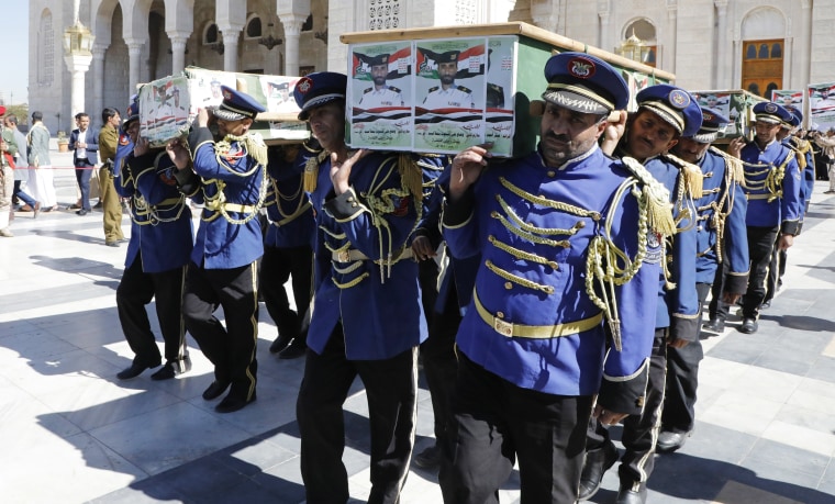 A Houthi honor guard Sunday carries the coffins of fighters killed in the U.S. and U.K. air strikes in Yemen.